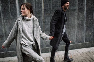 Beautiful couple in stylish clothes in gray tones, city