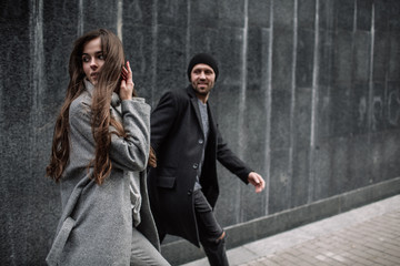 Beautiful couple in stylish clothes in gray tones, city