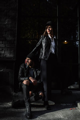 Beautiful girl. A model in a stylish wide-brimmed hat at a pedestrian crossing. Harmoniously similar clothes in gray tones. Street style shooting. Women's fashion.