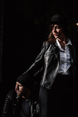Beautiful girl. A model in a stylish wide-brimmed hat at a pedestrian crossing. Harmoniously similar clothes in gray tones. Street style shooting. Women's fashion.