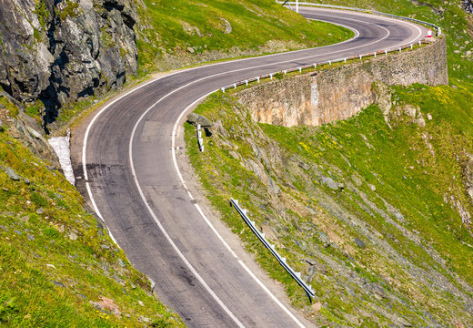 Transfagarasan road in Romanian mountains. winding serpentine among the grassy hills on a sunny morning