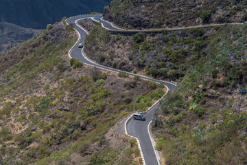 Schlängelnde Serpentine auf Teneriffa durch das Teno-Gebirge mit querstehendem Van