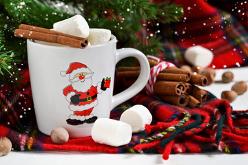 A cup of hot winter drink with marshmallow and cinnamon. New Year's background.