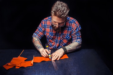 Worker of leather producing leather workpiece in the work area