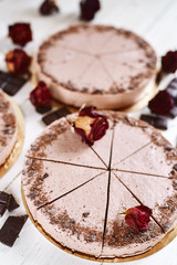 Chocolate mousse cheesecakes with a sprinkle of grated chocolate on a wooden table