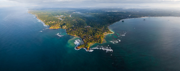 Aerial panorama of the cape of the town of Weligama with fisherman boats, beaches and waves...