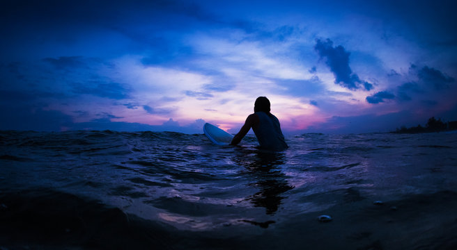 Surfer waits the wave in an ocean during sunset - Powered by Adobe