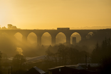 A Train passes over a cornish viaduct at sunrise, Moorswater, Liskeard, Cornwall, UK