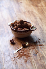 Vegan Chocolate Glazed Truffles in a jar, on wooden background.