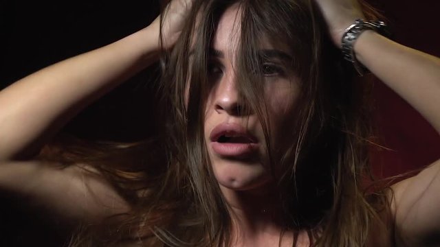A beautiful woman in a fury, growls with anger and spoils her hair