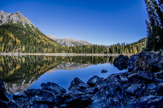 Obernbergersee in autumn with a surface reflection and a blue sky