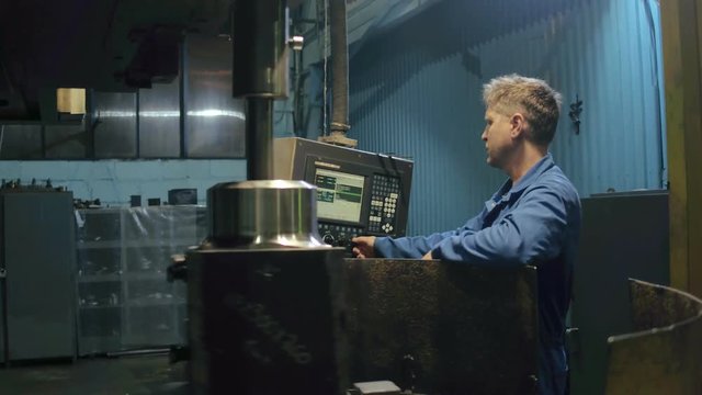 Factory workman making quality control metal detail on electronic equipment