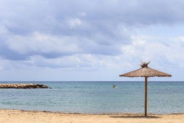 Beach umbrella of dried leaves near the sea. Travel vacations concept.