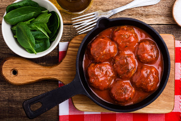 Beef meatballs in cast iron skillet on rustic wooden table