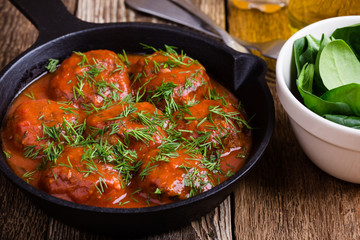 Beef meatballs in cast iron skillet on rustic wooden table