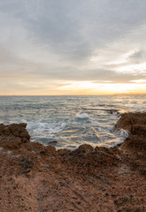The calm sea in a very cloudy sunset
