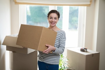 Woman carrying cardboard boxes in living room © WavebreakMediaMicro