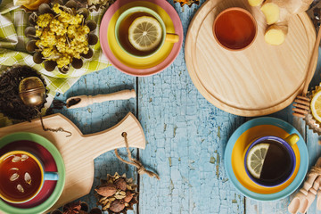 Cups with herbal tea and pieces of lemon, dried herbs and different decorations