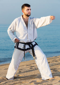 Man doing karate at ocean