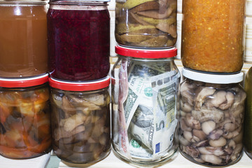 dollar in a glass jar on the background of canned