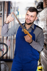 Cheerful male worker showing his working tools