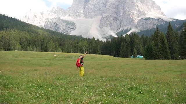 Turista ammira gioioso il panorama delle Dolomiti