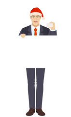 Businessman in Santa hat holding white blank poster and showing the business card