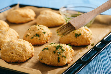 Homemade garlic cheese biscuits on wooden background.