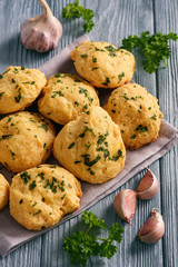 Homemade garlic cheese biscuits on wooden background.