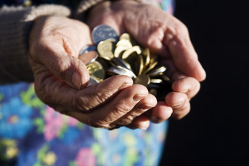 Coins in old granny hands close up