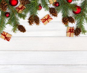 Christmas decoration. Cones and twigs pine tree (Pseudotsuga menziesii, Douglas fir), gift boxes and christmas balls on background of white painted wooden planks. Top view, flat lay.