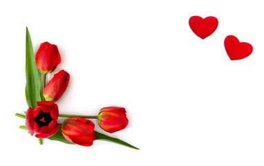 Beautiful red tulips and two hearts on white background with space for text. Top view, flat lay. Valentine decoration.