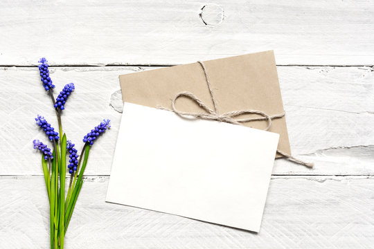 blank white greeting card and envelope with spring blue flowers bouquet