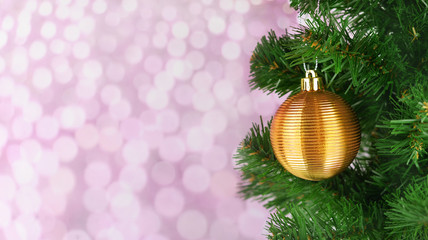 holiday decoration toy ball on a Christmas tree in golden color