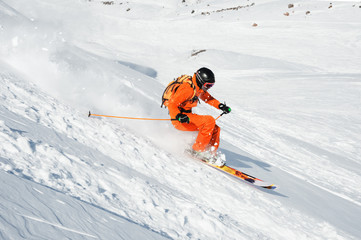 Fototapeta na wymiar Ski athlete in a fresh snow powder rushes down the snow slope