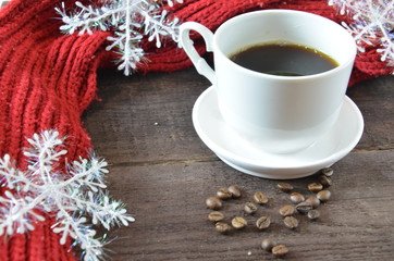 cup of coffee with grains, red burgundy scarf, wooden, winter concept, hot drink, snowflakes on dark background