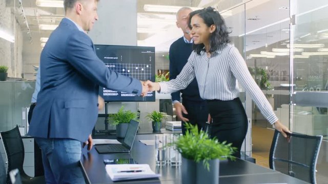 Diverse Team of Successful Businesspeople Enters Conference Room, they all Greet Each Other, Shake Hands and Sit Down at the Big Table. RED EPIC-W 8K Camera.