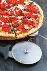 fresh and delicious Italian pizza on a wooden table and a pizza knife