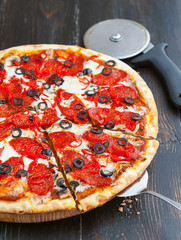 fresh and delicious Italian pizza on a wooden table and a pizza knife