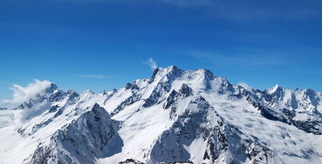 Panoramic view of snow covered mountain peaks and beautiful blue sky - Powered by Adobe