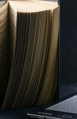 The old parted book is close-up and a modern e-book.