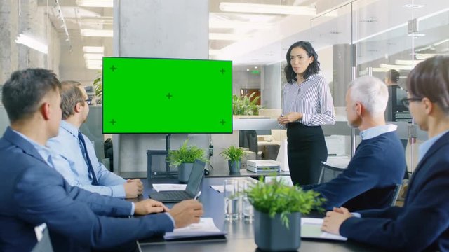Beautiful Businesswoman Gives Report/ Presentation to Her Business Colleagues in the Conference Room, She Interacts with Wall TV with Green Chroma Key Screen. RED EPIC-W 8K Camera.