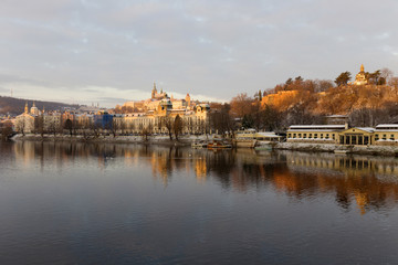 Obraz premium Early Morning Christmas snowy Prague Lesser Town with gothic Castle above River Vltava, Czech republic