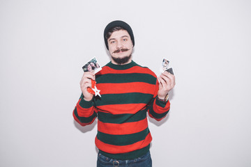 boy wearing bobble hat holds summer photos and christmas decoration