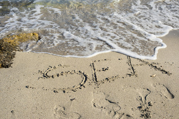 sea written in a sandy tropical beach

