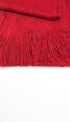 Wool red scarf with fringe on a white background. Space for text