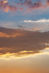 The vertical view of sky background or texture at the sunset time with clouds. Copy space