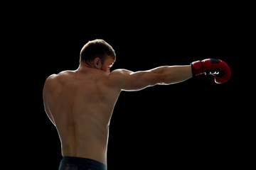 Fighter training on his own. Young man throwing kicks with boxing gloves on hands. Preparing for a...