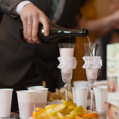 Man pouring champagne by the glasses