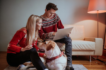 Christmas gifts and happiness between a young couple and a cute dog